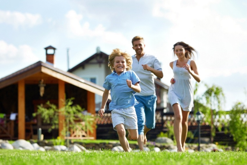 family happily running with house at the background